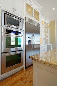 a kitchen with stainless steel appliances and marble counter tops