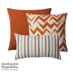 three orange and white pillows sitting next to each other