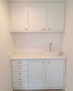 a white bathroom with cabinets and a sink