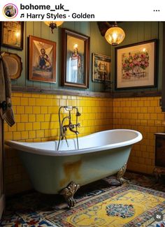 an old fashioned bathtub in a bathroom with pictures on the wall