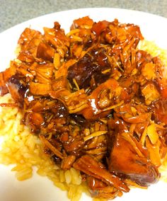 a white plate topped with rice and meat covered in gravy on top of it