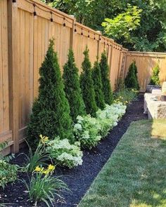 a wooden fence and some bushes in the yard