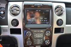 the interior of a vehicle with an entertainment system in it's center console and steering wheel controls