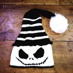 a black and white knitted hat with a jack - o'- lantern face