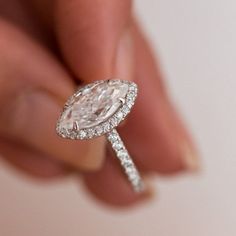 a person holding a diamond ring in their hand