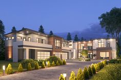 a large house with lots of windows and lights on it's front yard at night