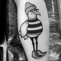 a black and white tattoo with a bird wearing a hat