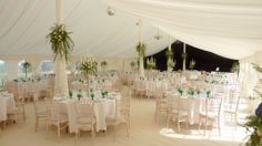 the inside of a large tent with tables and chairs set up for an event or party