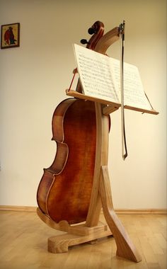 an old violin is sitting on a stand with sheet music in it's back