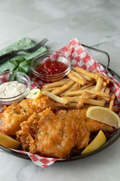 a plate full of fried fish and fries with ketchup