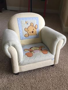 a child's chair with a winnie the pooh applique on it