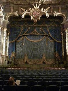 an ornate stage with blue curtains and gold trim