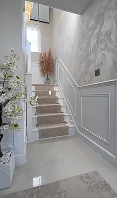 the stairs are lined with white flowers in vases and on either side of them