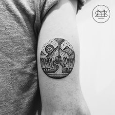 a man's arm with a mountain and river tattoo on the left upper arm