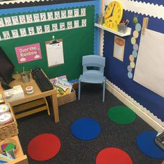 a classroom with colorful circles on the floor and a computer desk in front of it