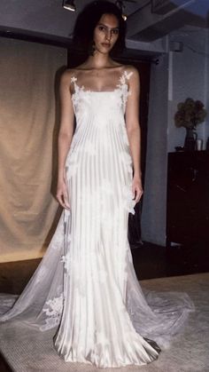 a woman in a white wedding dress posing for the camera