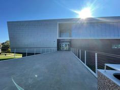 the sun shines brightly in front of a building with a ramp leading up to it