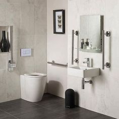 a bathroom with a toilet, sink and mirror next to each other on the wall