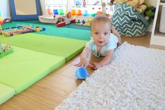 a baby laying on the floor playing with toys