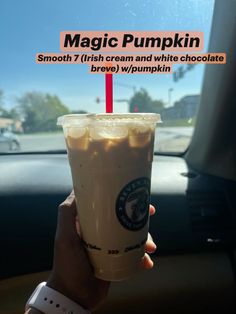 a person holding up a drink in front of a car window that says magic pumpkin smoothie