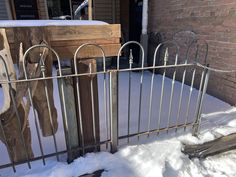 an iron fence with snow on the ground