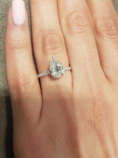 a woman's hand with a ring on it and a diamond in the middle