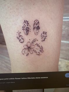 a small dog paw tattoo on the leg