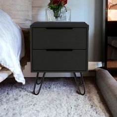 a night stand with two drawers and a flower in a vase on the top shelf