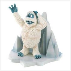 a toy gorilla standing on top of an iceberg with his arms in the air