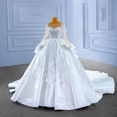 a white wedding dress on display in a room