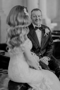 a man in a tuxedo sitting next to a woman wearing a wedding dress