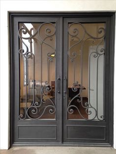 an ornate iron door with glass panels