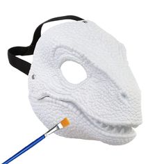 a white mask with a blue toothbrush sticking out of it's mouth on a white background