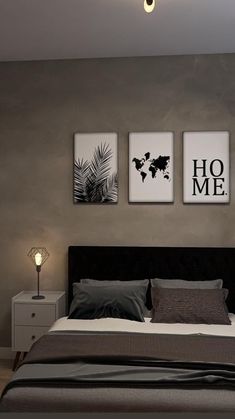 a bed sitting under two pictures on the wall next to a night stand and lamp