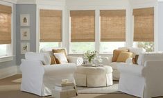 a living room filled with furniture and windows covered in shades of brown and white blinds