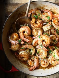 a pan filled with cooked shrimp and garnished with parsley