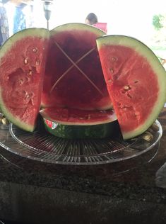 a watermelon cut in half sitting on top of a metal rack with another piece missing