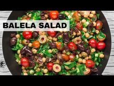 a salad with tomatoes, olives and other vegetables is shown in the middle of this video