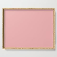 an empty wooden frame on a wall with pink paint in the center and bamboo trim around the edges