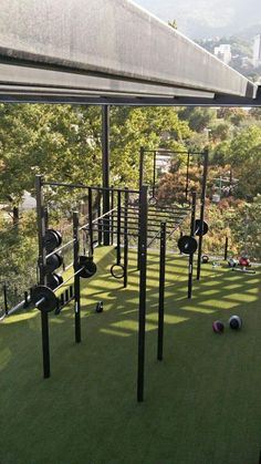 an outdoor gym with several balls on the grass