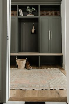 an entryway with built - in bookshelves, rug and baskets on the floor