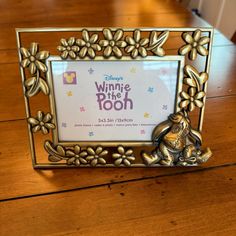 a winnie the pooh frame sitting on top of a wooden table