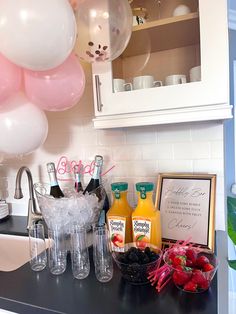 a kitchen counter topped with lots of food and balloons