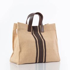 Brown eco-chic jute tote, seamlessly blending style and sustainability with leather handles for a touch of sophistication. Contains a magnetic closure, canvas interior lining, genuine leather handles with a 4" drop, an inner zip pocket and reinforced bottom support. Beige Bag With Canvas Lining For On-the-go, Brown Canvas Bag With Handles, Summer Shopping Bag With Leather Trim, Brown Canvas Bag With Handles For On-the-go, Eco-friendly Canvas Shoulder Bag With Leather Handles, Natural Bags With Leather Trim And Double Handle, Natural Bag With Leather Trim And Double Handle, Modern Brown Canvas Bag With Double Handle, Beige Jute Top Handle Bag