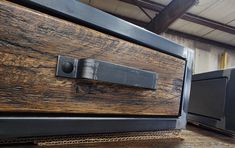 a close up of a drawer on a wooden table with metal handles and knobs