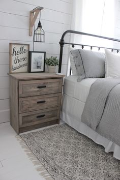 a bedroom with a bed, nightstand and pictures on the wall