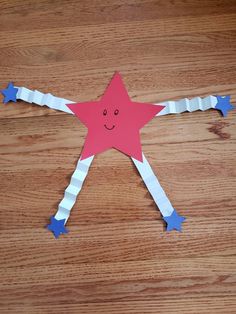 a paper cut out of a star on top of a wooden table with blue and white strips