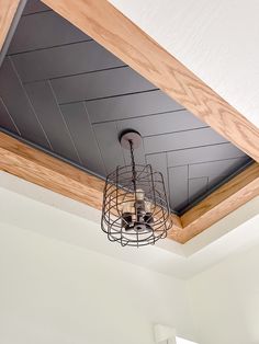 a light that is hanging from the ceiling in a room with white walls and wood trim