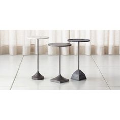 three black and white tables sitting next to each other on top of a tile floor