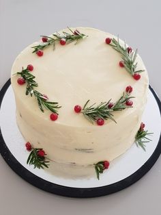 a cake with white frosting and red berries on top